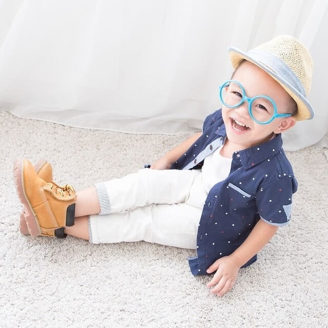 happy little boy wearing blue rimmed eyeglasses